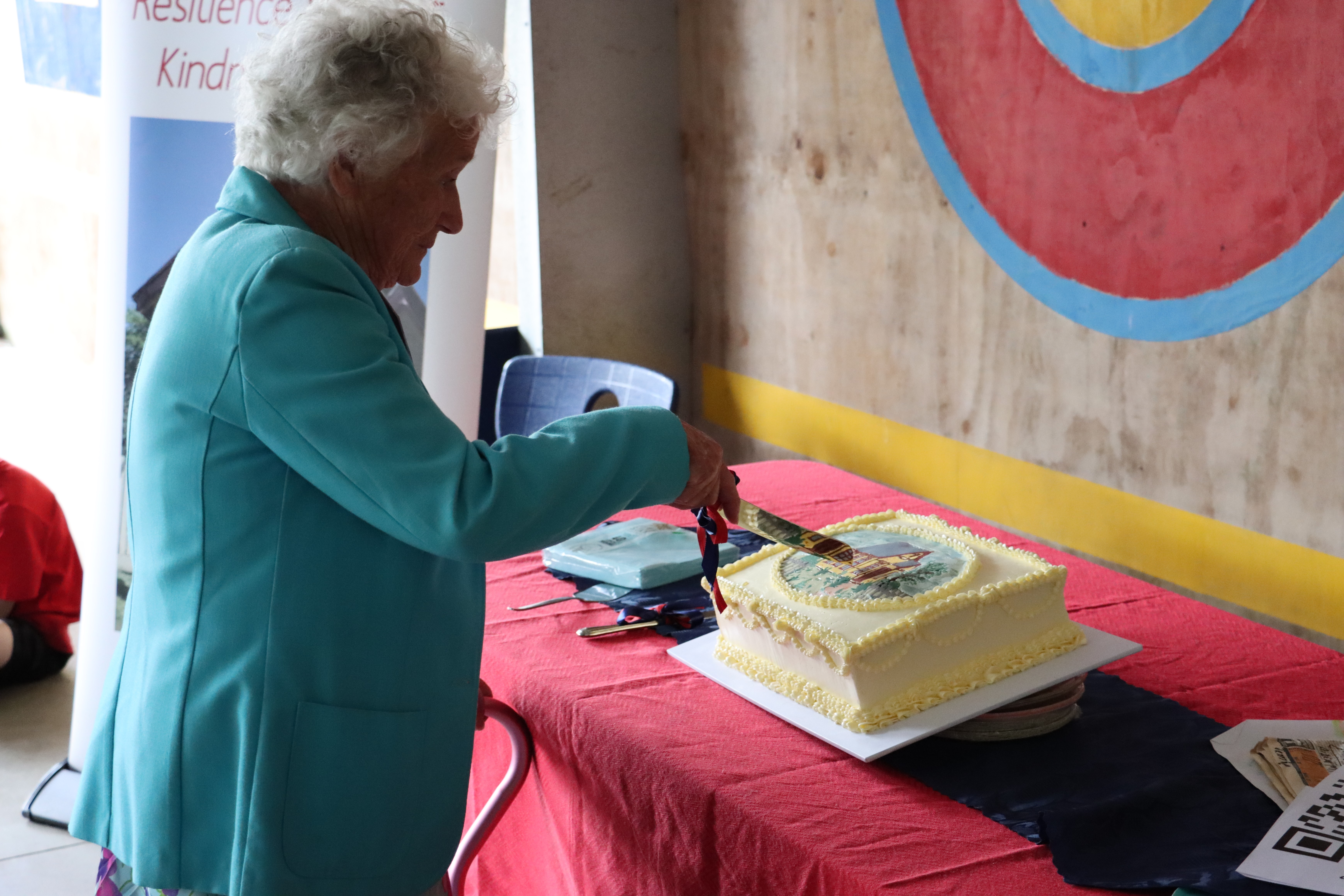 /uploaded_files/media/gallery/1765842590Pat cutting cake web.JPG